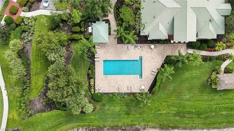 an aerial view of a house with a yard and lake view in back
