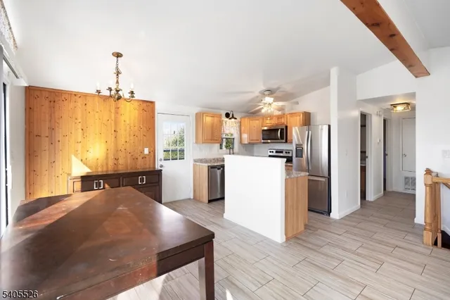 a kitchen with kitchen island a refrigerator stove and oven