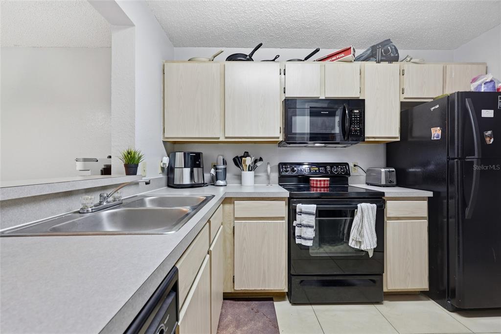 3705 Southwest 27th Street, Unit 717 Gainesville, FL 32608 - Photo 7 of 24 a kitchen with stainless steel appliances granite countertop a sink stove and refrigerator