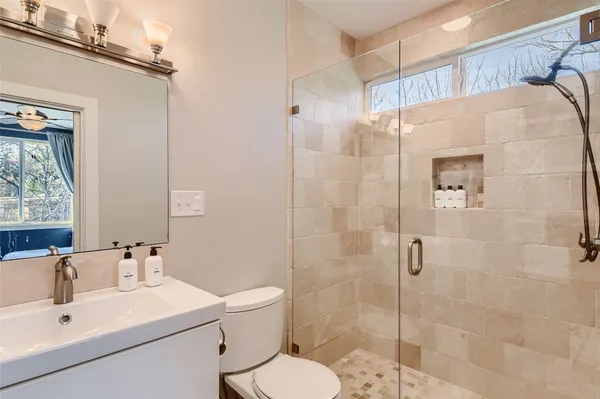 a bathroom with a sink mirror toilet and shower