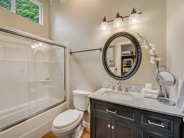 a bathroom with a granite countertop toilet a sink and a mirror