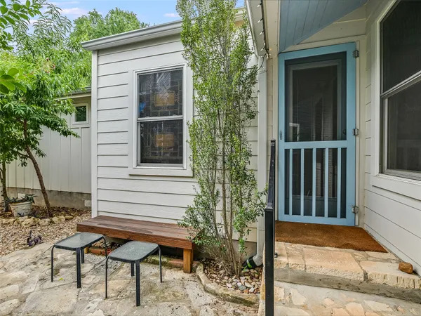 a view of a wooden bench sitting in front of a house