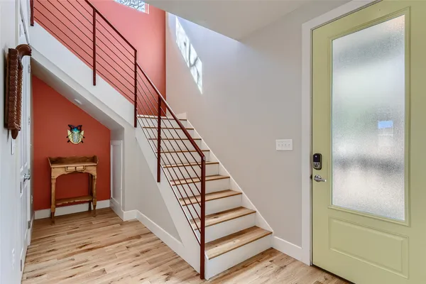 a view of a hallway with wooden floor and stairs