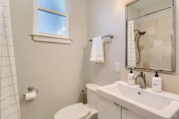 a bathroom with a sink mirror and toilet