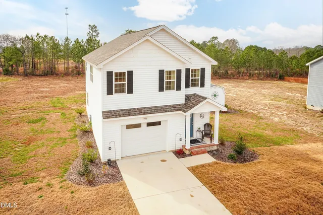 a view of a white house with a yard