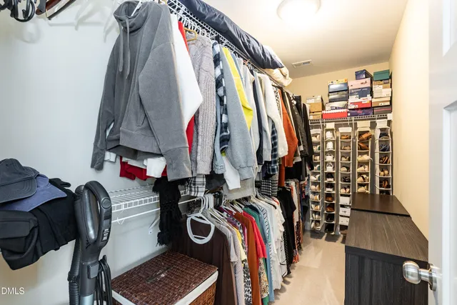a view of walk in closet with clothes and shoes