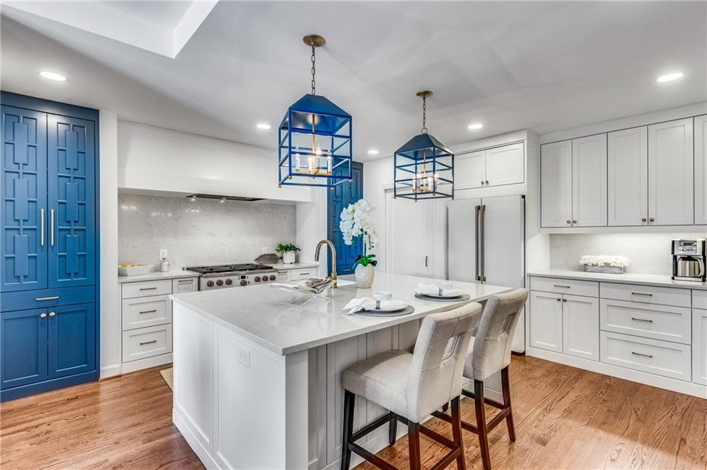 a kitchen with stainless steel appliances a dining table chairs stove and sink