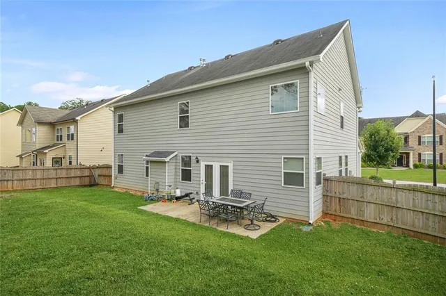 a view of a house with a backyard and a table and chairs