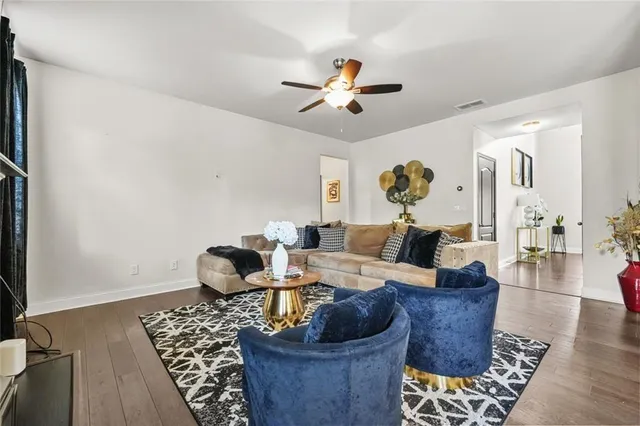 a living room with furniture two large windows and a fireplace