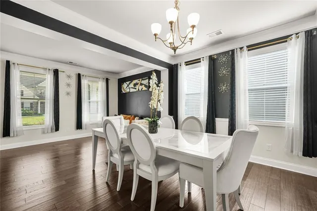 a kitchen with stainless steel appliances granite countertop a sink a stove a refrigerator cabinets and chairs