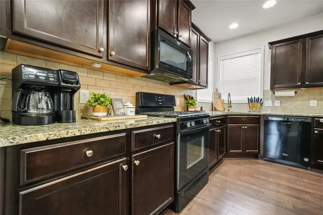 a open kitchen with a table chairs and wooden floor