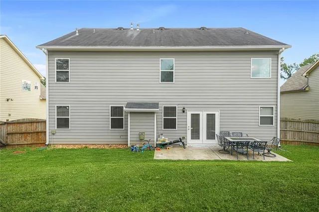 a front view of a house with a garden and chairs
