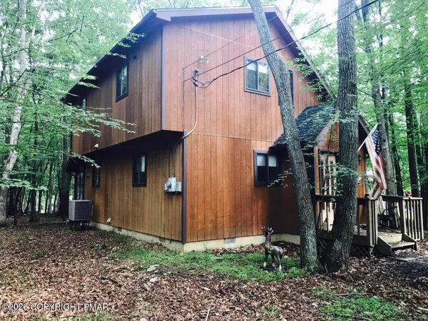 a view of a house with backyard and trees