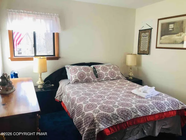 a bedroom with a bed and a painting on the wall