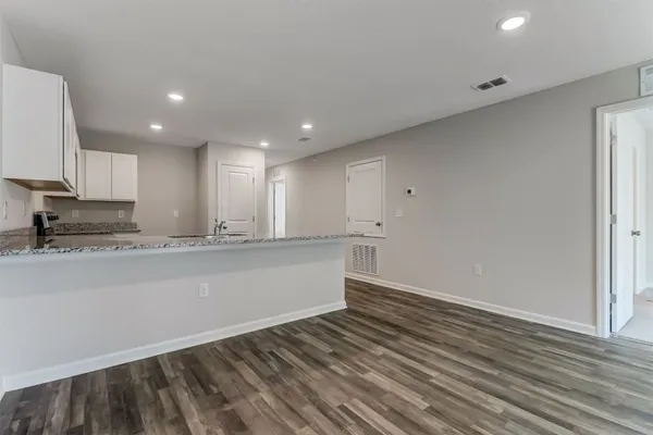 a view of kitchen with granite countertop cabinets and wooden floor