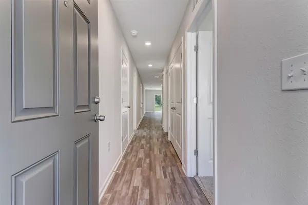 a view of a hallway with wooden floor