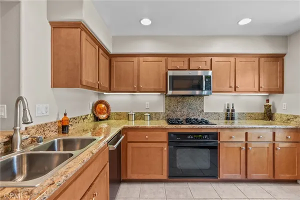 a kitchen with stainless steel appliances granite countertop a sink stove and cabinets