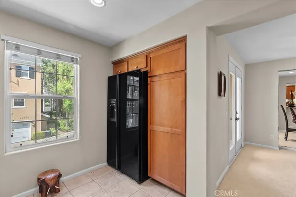 a view of hallway with windows and refrigerator