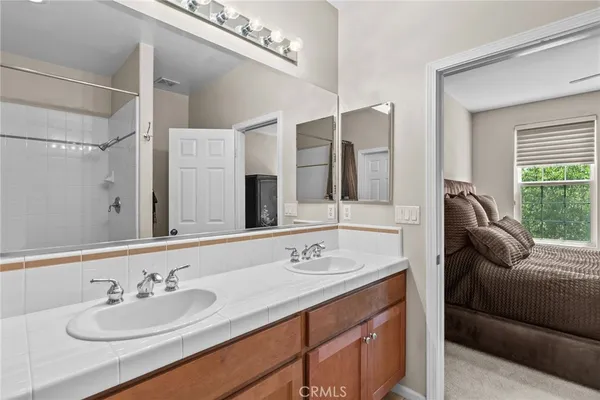 a en suite bathroom with a granite countertop sink and a mirror