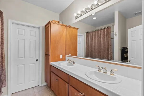 a bathroom with double vanity and a mirror