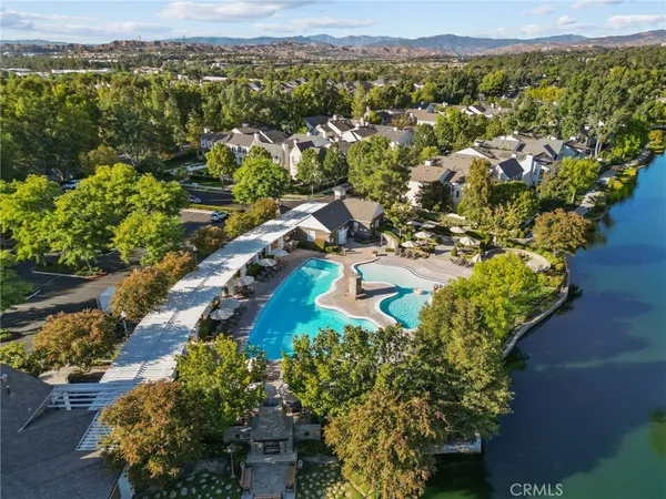 an aerial view of residential houses with outdoor space and trees