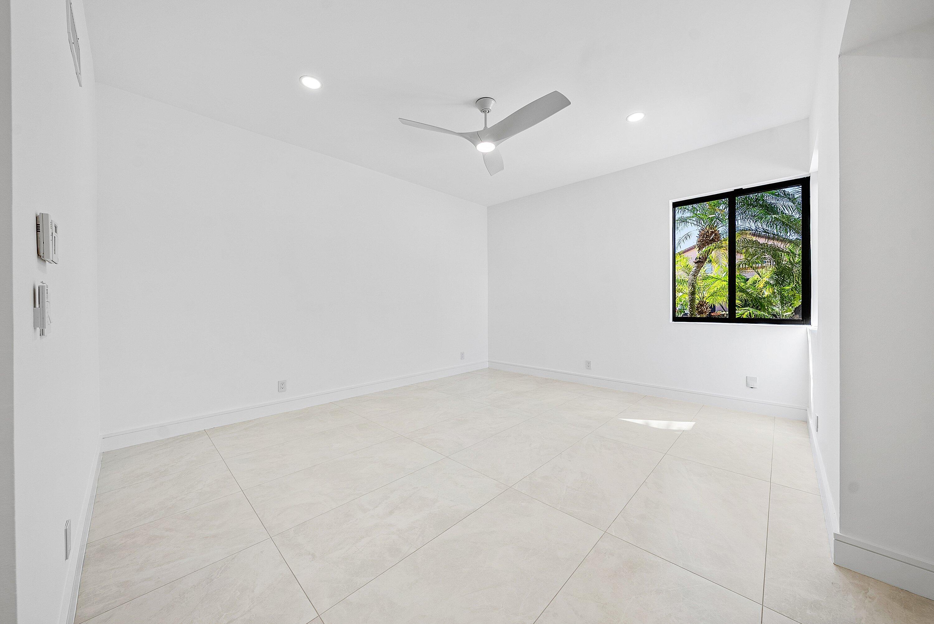 6547 Via Rosa Boca Raton, FL 33433 - Photo 19 of 55 an empty room with windows and ceiling fan