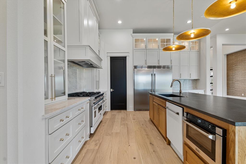 312 Longview Place Heath, TX 75032 - Photo 22 of 40 a large kitchen with stainless steel appliances granite countertop a lot of counter space and wooden floors
