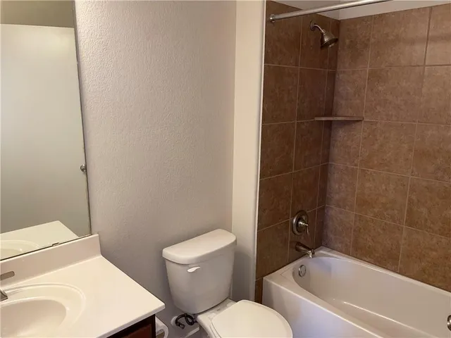 a white toilet sitting next to a bath tub