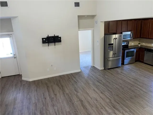 a kitchen with a refrigerator and a stove top oven