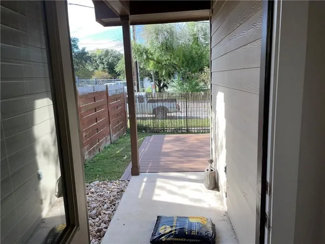 a side view of a house with a wooden fence