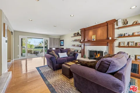 a living room with furniture a large window and a fireplace