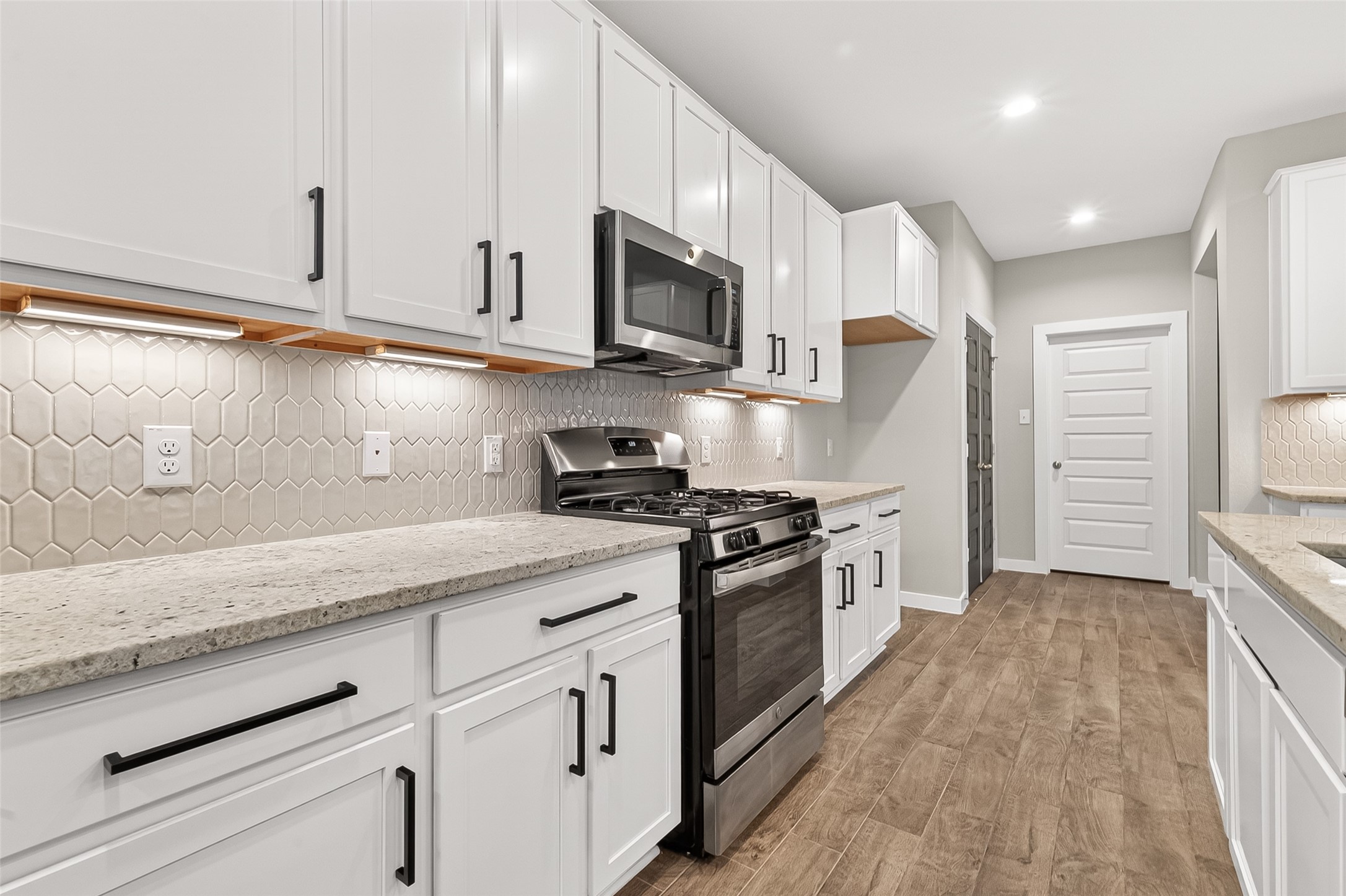 2142 Reed Cave Lane Spring, TX 77386 - Photo 18 of 50 a kitchen with stainless steel appliances granite countertop grey cabinets a stove top oven a sink and dishwasher