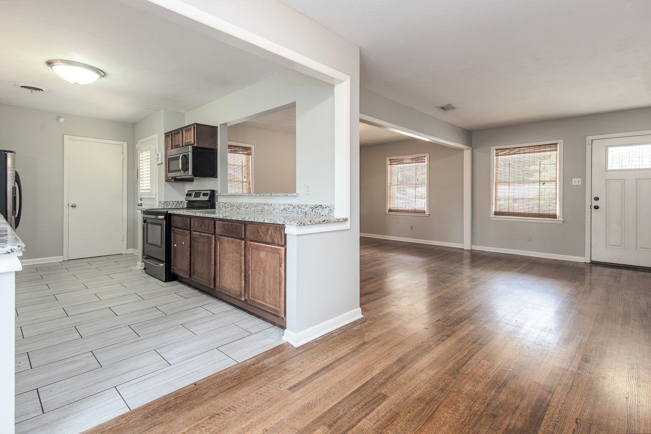 5538 Melvin Road Memphis, TN 38120 - Photo 6 of 25 a kitchen with stainless steel appliances granite countertop a stove top oven a sink with wooden floors