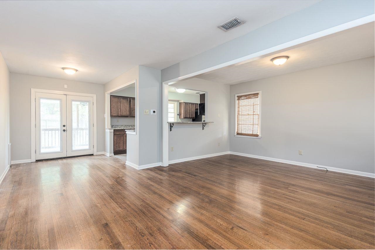 5538 Melvin Road Memphis, TN 38120 - Photo 7 of 25 a view of empty room with wooden floor and windows