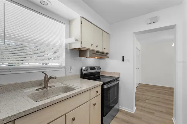 a kitchen with a sink cabinets and a window