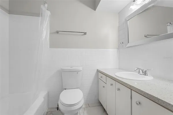 a bathroom with a toilet sink vanity and mirror