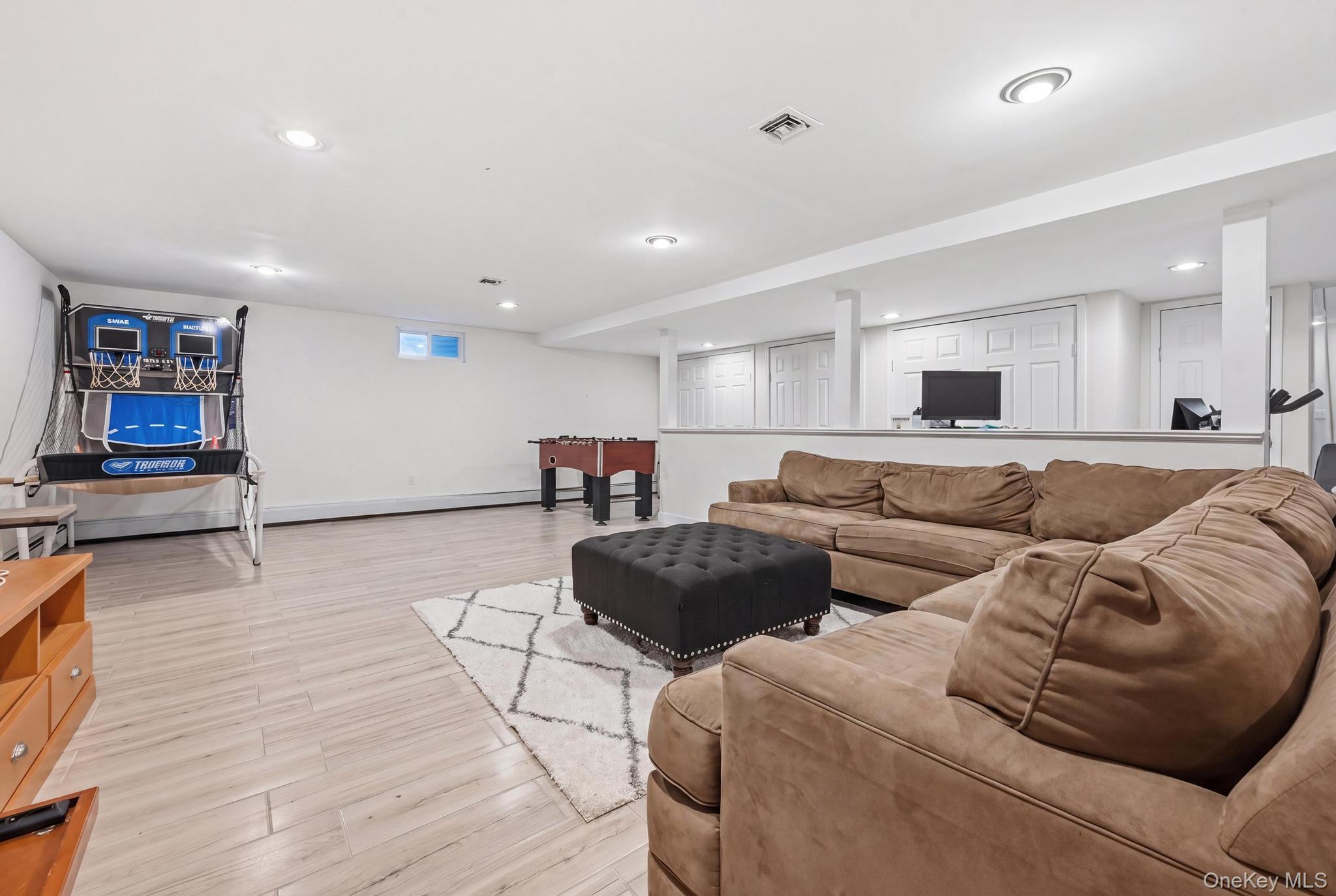 19 Sunset Road West Albertson, NY 11507 - Photo 21 of 24 Finished lower level featuring recessed lighting, light wood-finish flooring, and crisp white walls