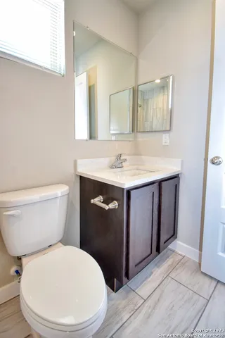 a bathroom with a toilet a sink and mirror