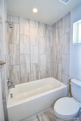 a white bath tub sitting next to a white toilet