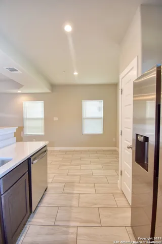 a view of a kitchen with a sink and a refrigerator