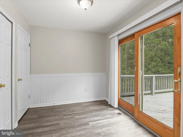 a view of an empty room with wooden floor and windows