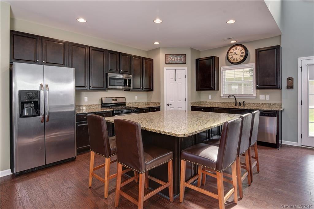85 Roanoke Road Fletcher, NC 28732 - Photo 8 of 24 a kitchen with granite countertop a table chairs stainless steel appliances and wooden floor