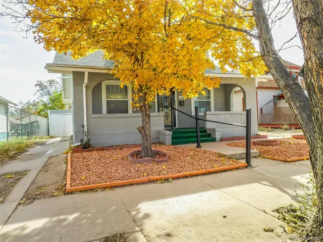 a front view of a house with a tree