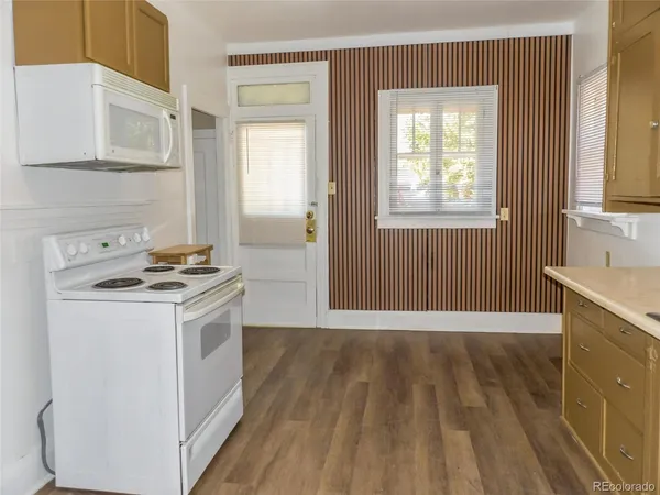 a kitchen with a stove and a white wooden cabinets