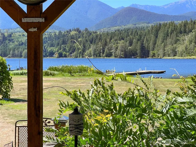 a view of a house with a big yard and large tree