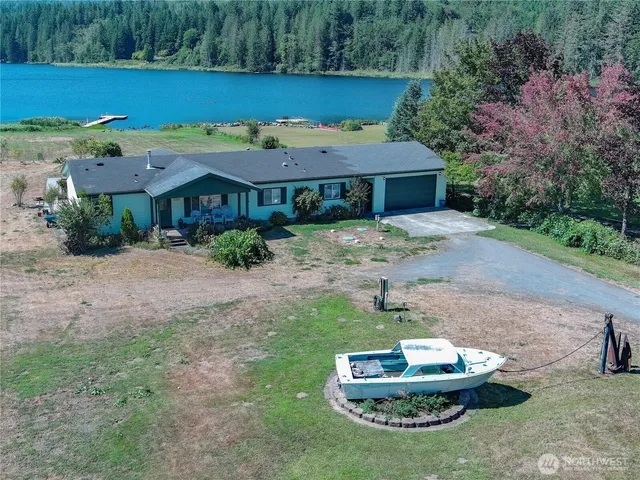 a view of a lake in front of a house with a yard