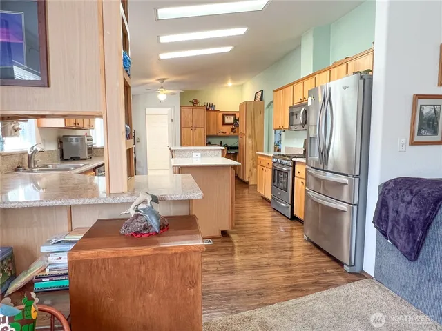 a kitchen with sink a refrigerator and chairs