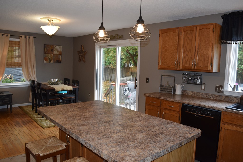 54 Luden Street Springfield, MA 01118 - Photo 7 of 24 a kitchen with kitchen island a stove a sink a refrigerator dining table and chairs