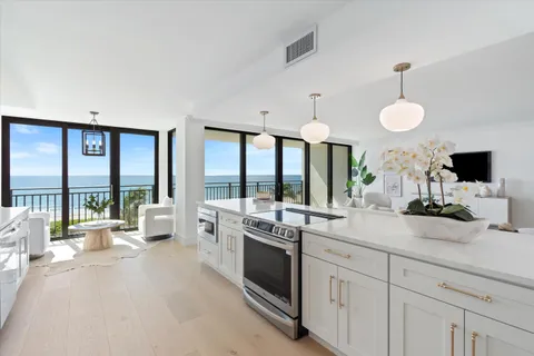 a large white kitchen with a large window and stainless steel appliances