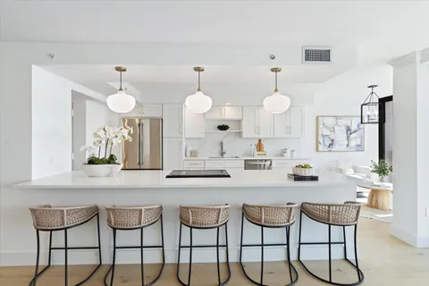 a kitchen with a dining table cabinets and chairs